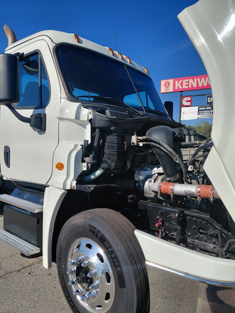 Truck engine bay of a Freightliner PT126064S T showing radiator area and visible engine components.