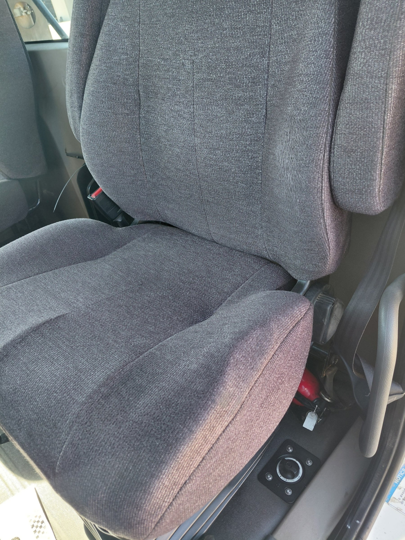 Truck interior seat view from 2018 Freightliner PT126064S T showing fabric seat with controls on side including seat adjustment knob and armrest.