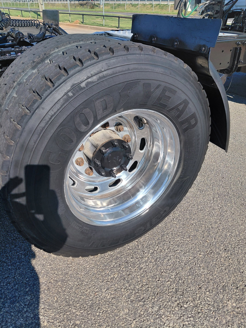 Goodyear rear tire on a Freightliner tractor showing Goodyear lettering and polished chrome wheel with lug nuts and hub.