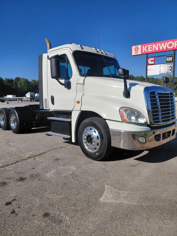 Truck cab and front of a Freightliner PT126064S conventional sleeper tractor showing large grille and side mirrors.