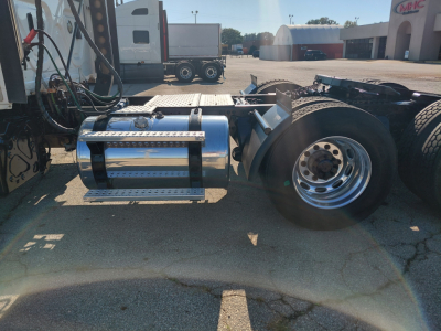 Truck chassis with chrome fuel tank and dual rear wheels showing undercab view; vocational heavy truck components visible.