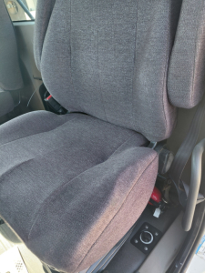 Truck interior seat view from 2018 Freightliner PT126064S T showing fabric seat with controls on side including seat adjustment knob and armrest. 