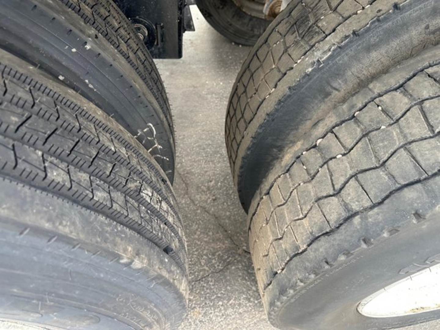 Tandem axle trailer tires close-up showing tread patterns and sidewalls for a Brazos air ride bottom dump trailer.