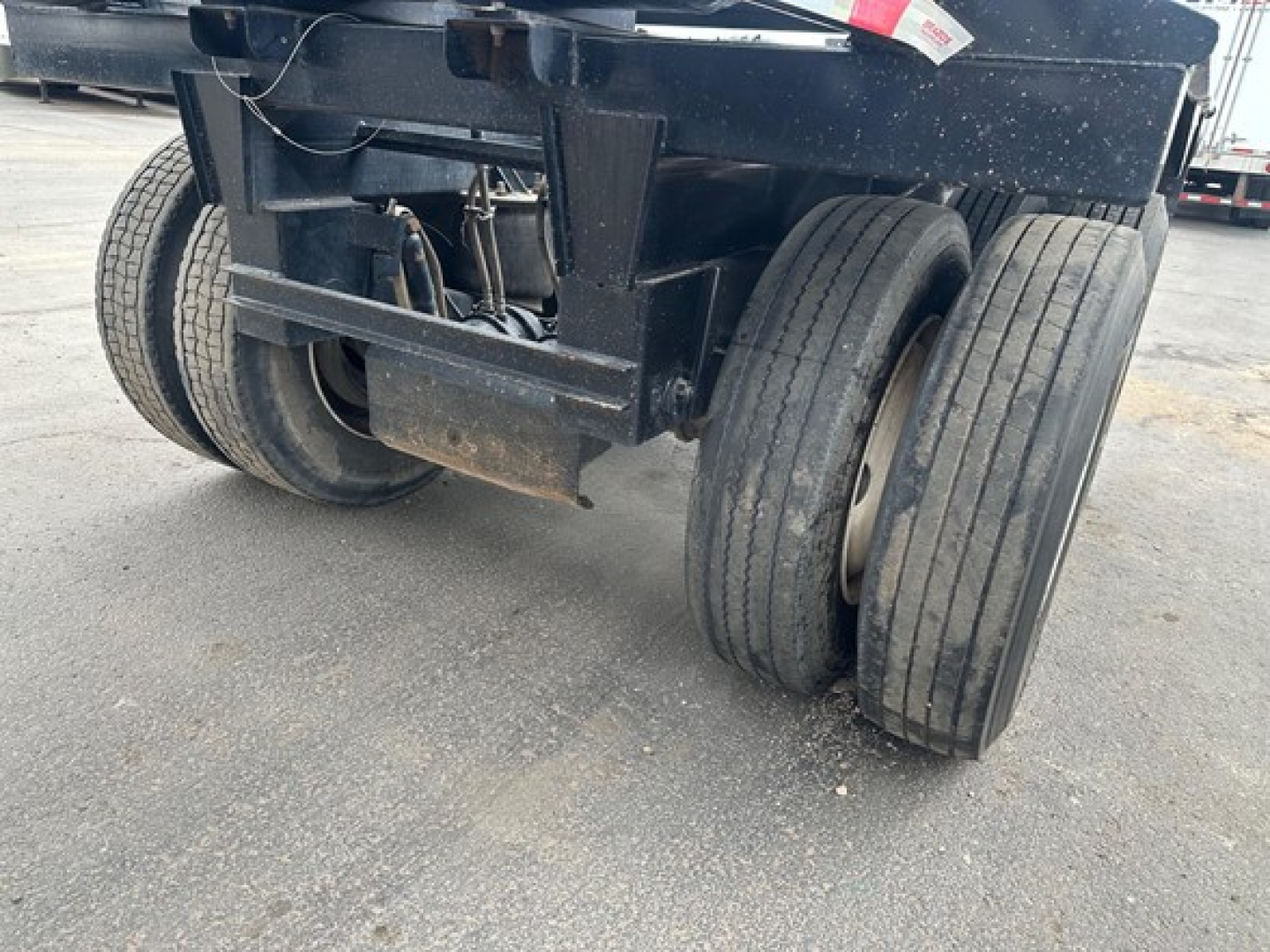 Trailer rear axle and wheels of a Brazos air ride bottom dump trailer showing dual rear axles and tires.