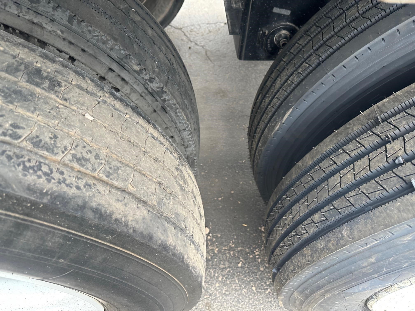 Dump trailer wheel view showing dual tires with tread and sidewall details.