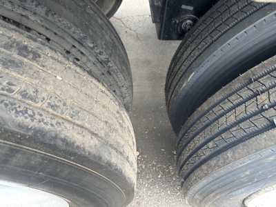 Dump trailer wheel view showing dual tires with tread and sidewall details.