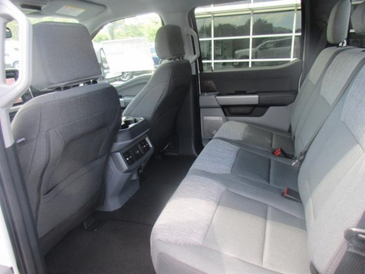 Truck interior rear seat area of a 2026 Ford F250 crew cab showing gray cloth seats and rear ventilation.