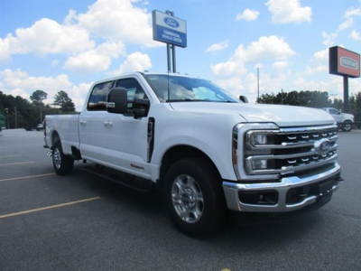 Ford F-250 pickup truck, white, 4-door crew cab, chrome front grille, in a dealership lot. 2026 model with Ford badge visible.