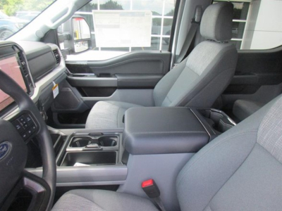 Interior of a 2026 Ford F-250 pickup truck showing front seats, center console, and dashboard with gray fabric upholstery.