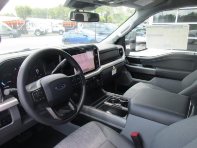Ford F-250 interior view showing steering wheel and large touchscreen infotainment system in the dash.