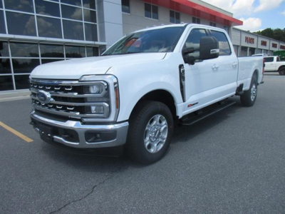 Ford F-250 pickup truck in white, front three-quarter view, chrome grille, large towing mirrors, badge family visible in showroom lot.