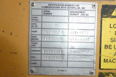 Identification plate on Caterpillar machinery with serial number, arrangement number, engine, transmission, torque converter, generator, axle, lower module labels and numbers.