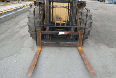 Forklift with extended rust-colored forks in front view showing pallet forks attached to carriage and tires.