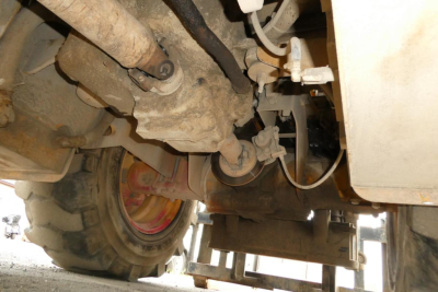 Truck lift equipment underside showing hydraulic lines and wheel, Master Craft C06-10116 component labels not clearly visible.
