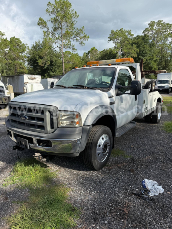Ford F-550 tow truck, front-left view, white cab with amber clearance lights on roof, extended wheelbase, stock number 31945-12, VIN 1FDAF56P66EA22502 visible in listing.