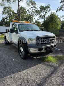 Ford F-550 tow truck cab and chassis with amber beacon light on top, white body, black bumper, visible Ford grille, front view.