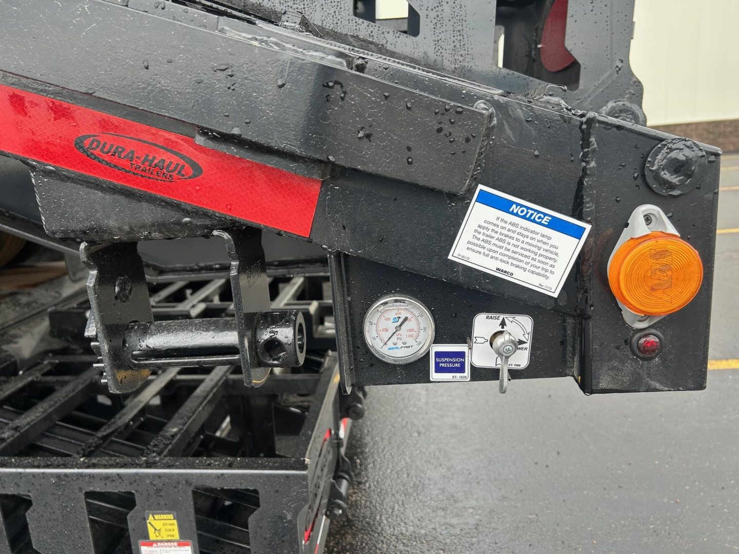 Trailer rear end showing Dura-Haul Beaver Tail label on black and red frame with gauges and orange rear light.