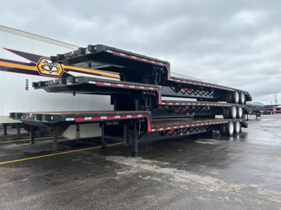 Trailer stack showing a beavertail drop deck trailer with multiple axles and black metal framing