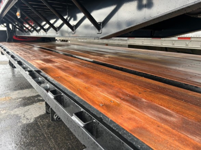 Drop deck trailer bed showing wooden planks and metal frame