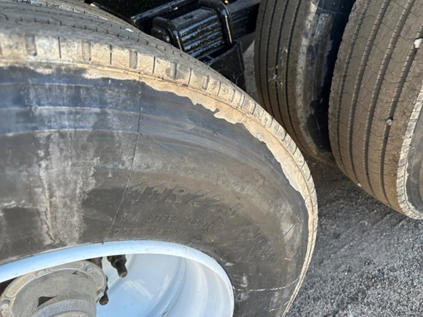 Tire and wheel area of a trailer showing large Dragster-style tire with visible tread and sidewall texture.