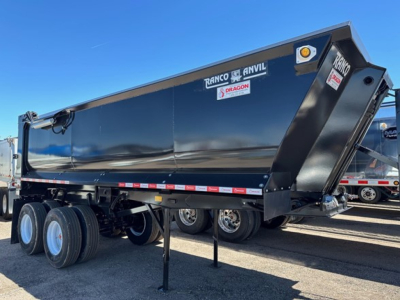 Tri-axle Ranco Anvil steel quarter frame end dump trailer with elliptical design showing brand labels and hydraulic apron in black finish.