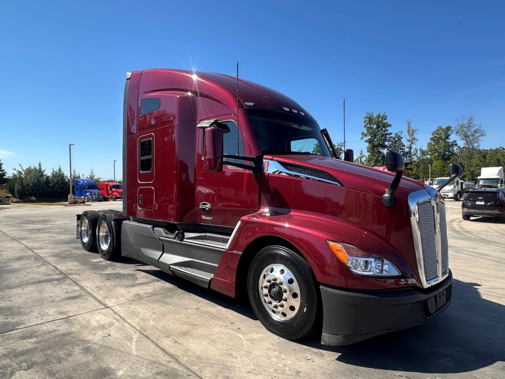 Kenworth T680 tractor unit in maroon with sleeper cab, front three-quarter view, no visible text on exhaust or panels.