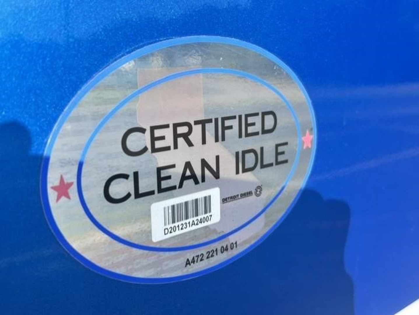 Certified Clean Idle sticker on blue truck door showing barcode and stars.