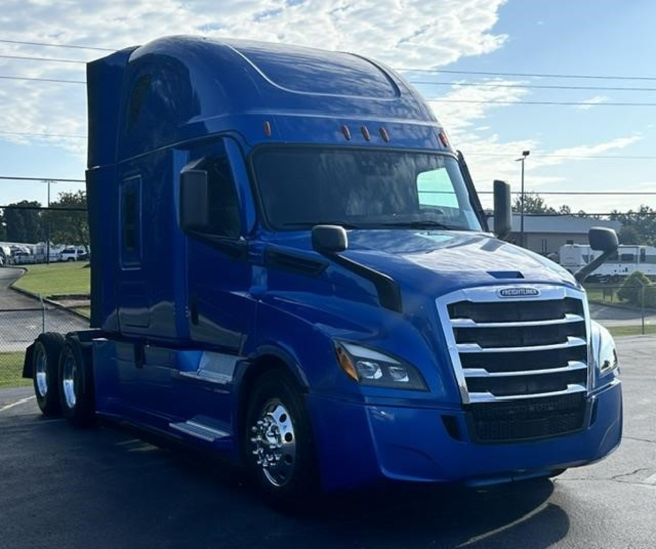 Freightliner Cascadia 126 semi-truck in blue, front-left view, with large chrome grille and sleeper cab.