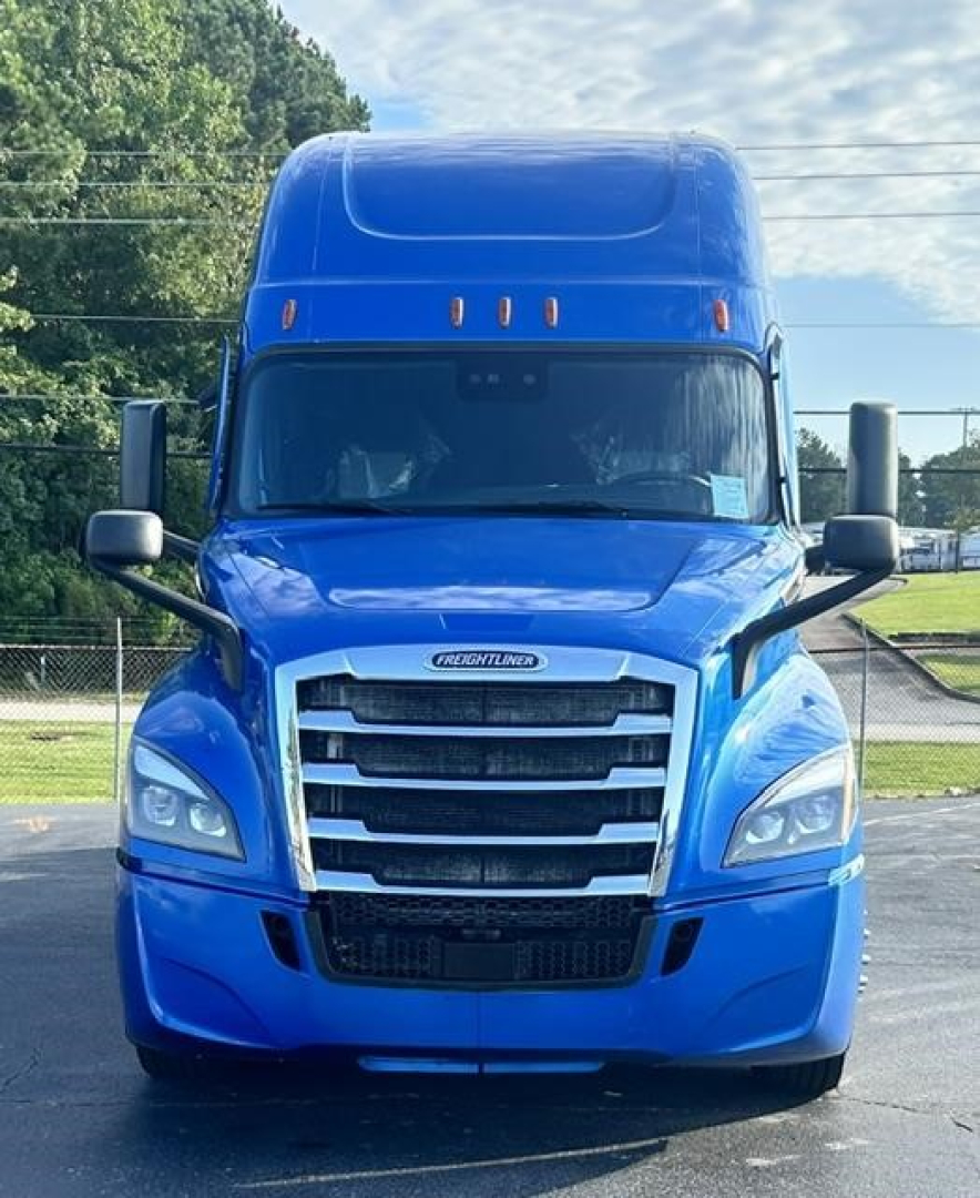 Truck front view of a blue 2022 Freightliner Cascadia 126 with large grille and sleeper cab.