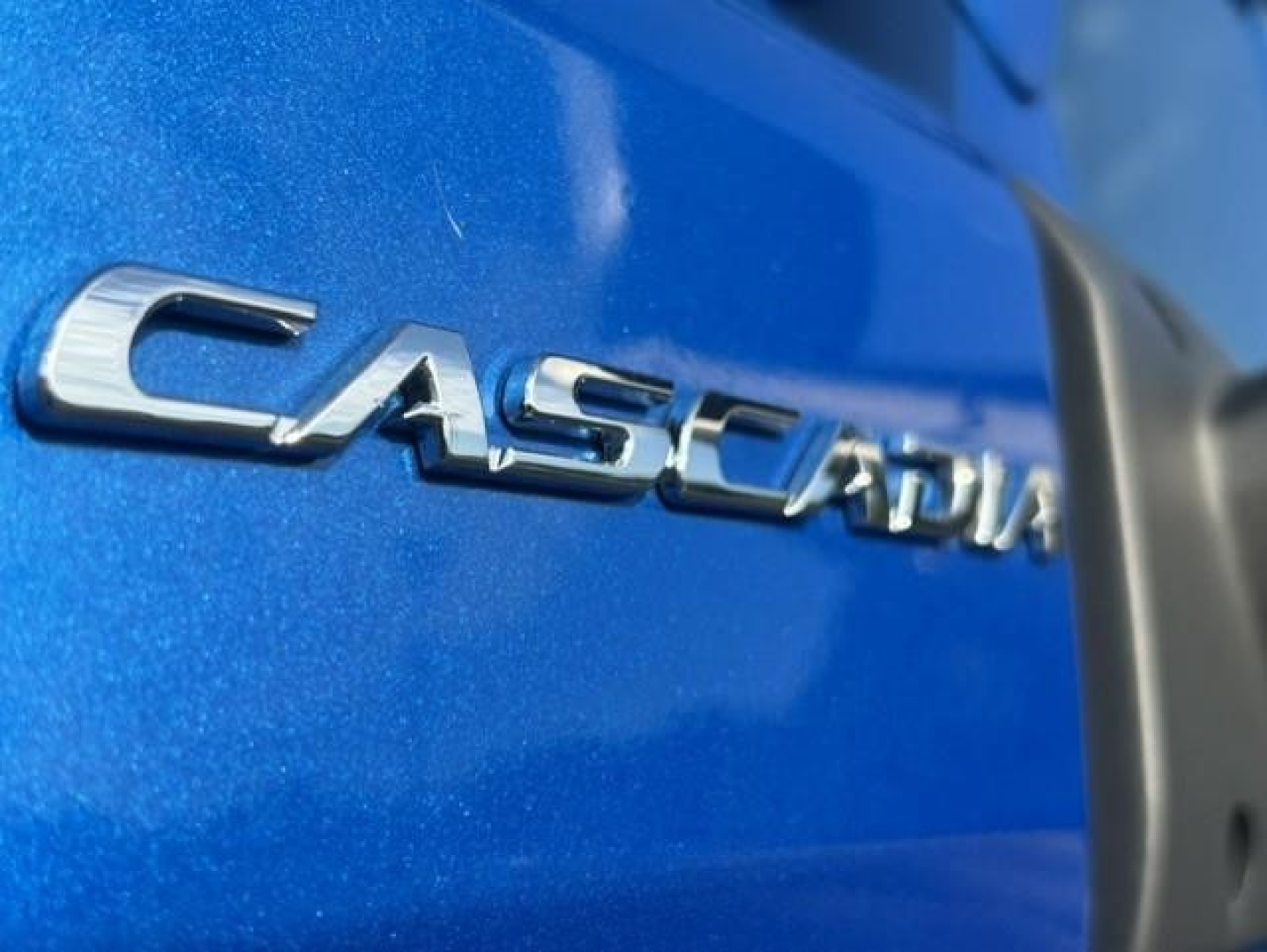 Cascadia badge on blue Freightliner truck showing Casadia lettering in chrome.