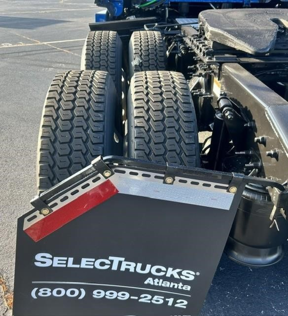Freightliner Cascadia truck rear wheels showing dual axle with mudflap reading SelectTrucks Atlanta and phone number.