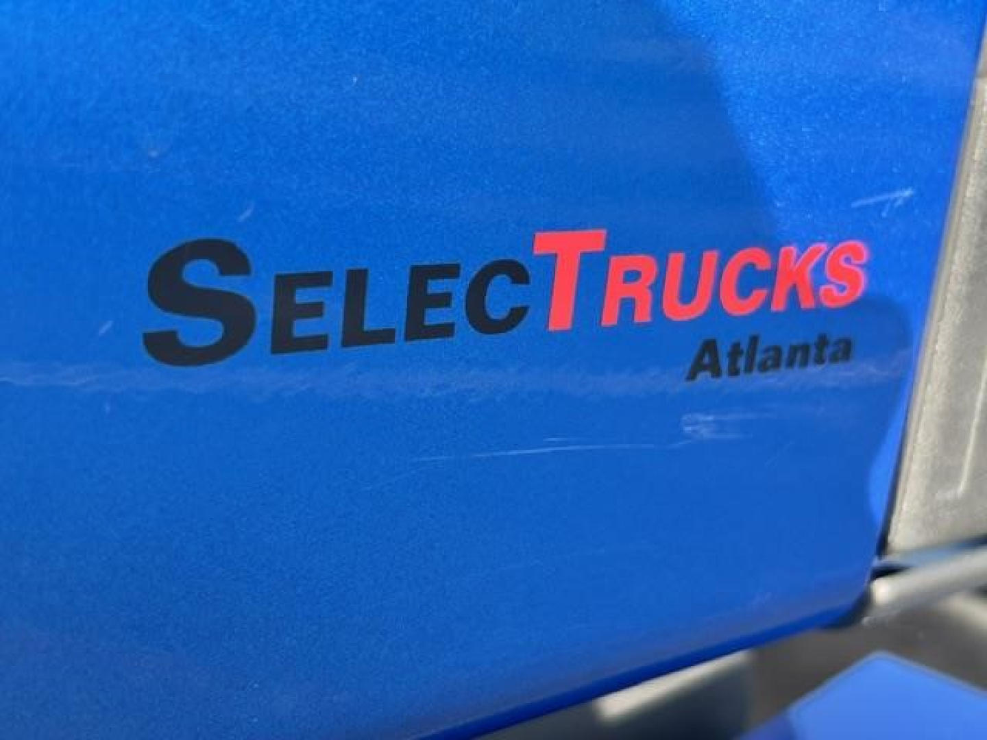Blue truck surface with text 'SELECTrucks Atlanta' logo on it.