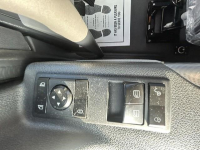 Trailer mirror controls panel in Freightliner Cascadia interior showing window switch and lock controls.