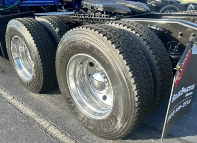 Freightliner Cascadia 126 rear dual tires and wheel well without visible damage; Goodyear tires; chrome rims; part of trailer hitch and undercarriage visible