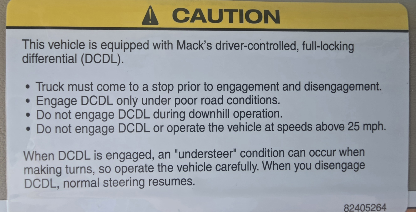 Caution sign on Mack vehicle indicating driver-controlled, full-locking differential (DCDL) rules and operation notes.