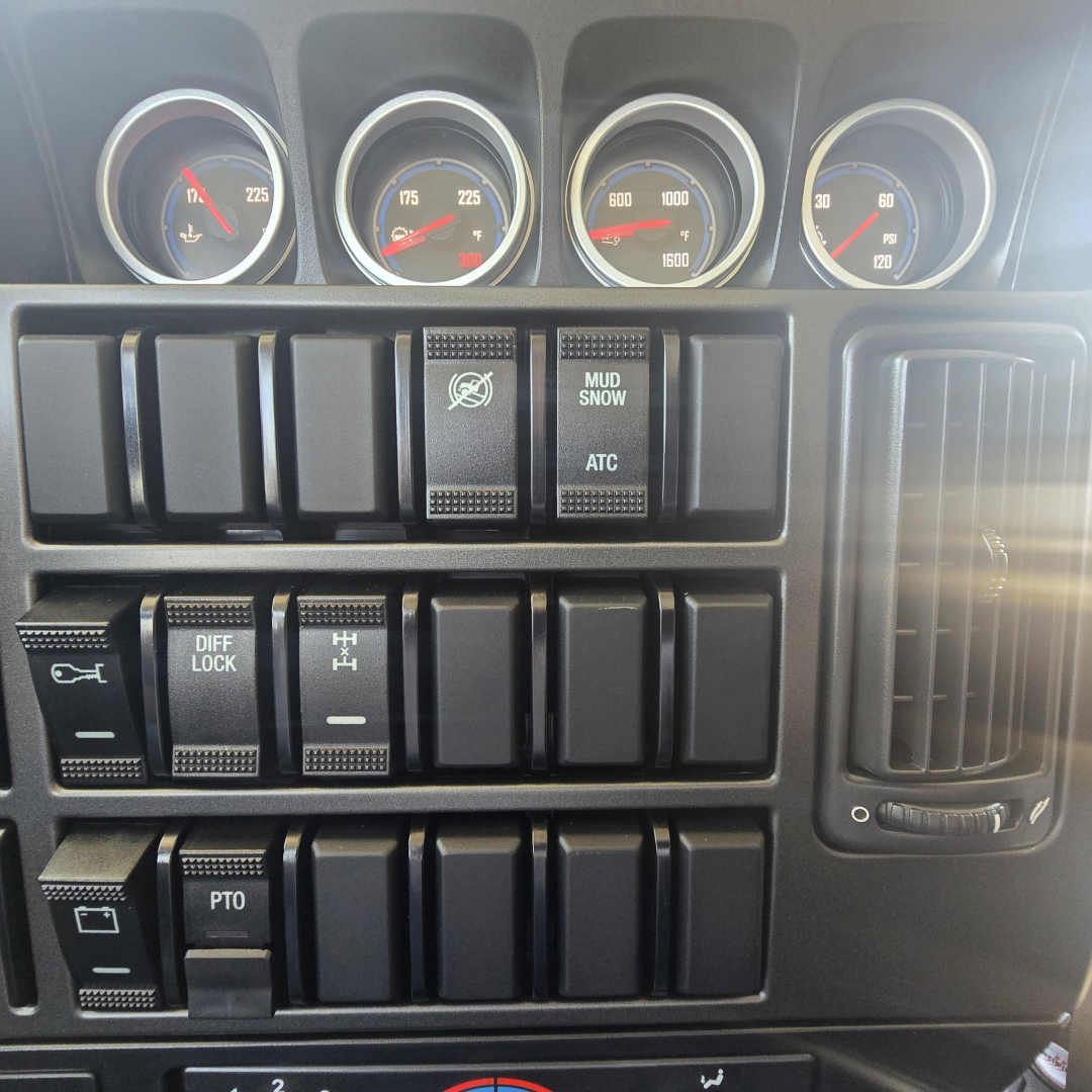 Mack PI64 dash cluster and control switches with gauges and push buttons.
