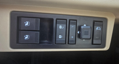 Dashboard control switches in an in-cab panel with window/lock controls and a small joystick-like control.