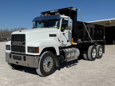 Dump truck in a white Mack PI64 cab with black dump body, front grille, dual rear wheels, and chrome bumper. View shows side profile and front-left angle.