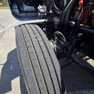 Mack PI64 chassis showing front wheel with tread and suspension components visible.
