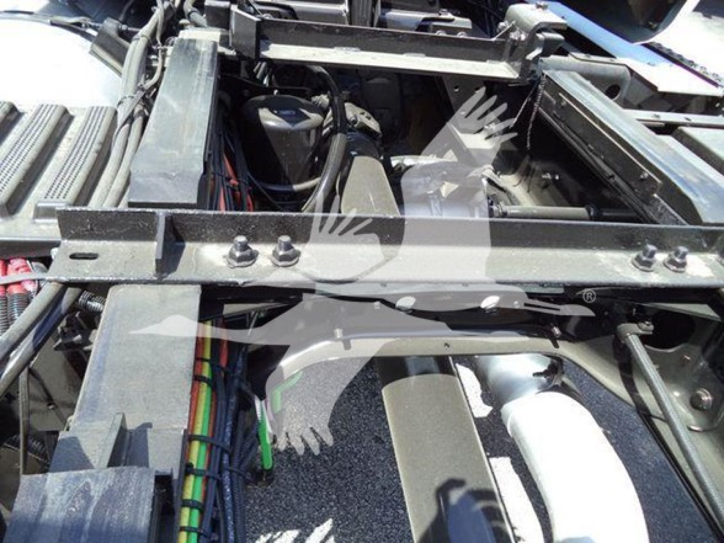 Truck chassis with engine bay and frame rails showing electrical wiring and components.