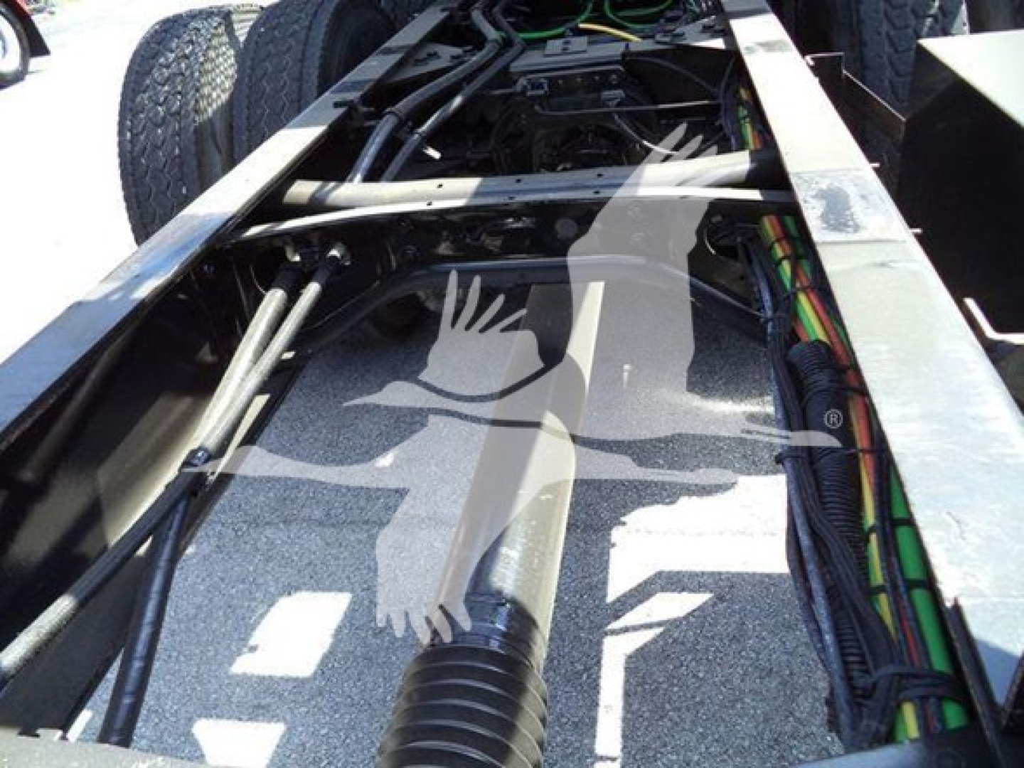Truck chassis with hydraulic lines and wiring harnesses visible in the frame of a 2016 International Workstar 7600 rollback truck.