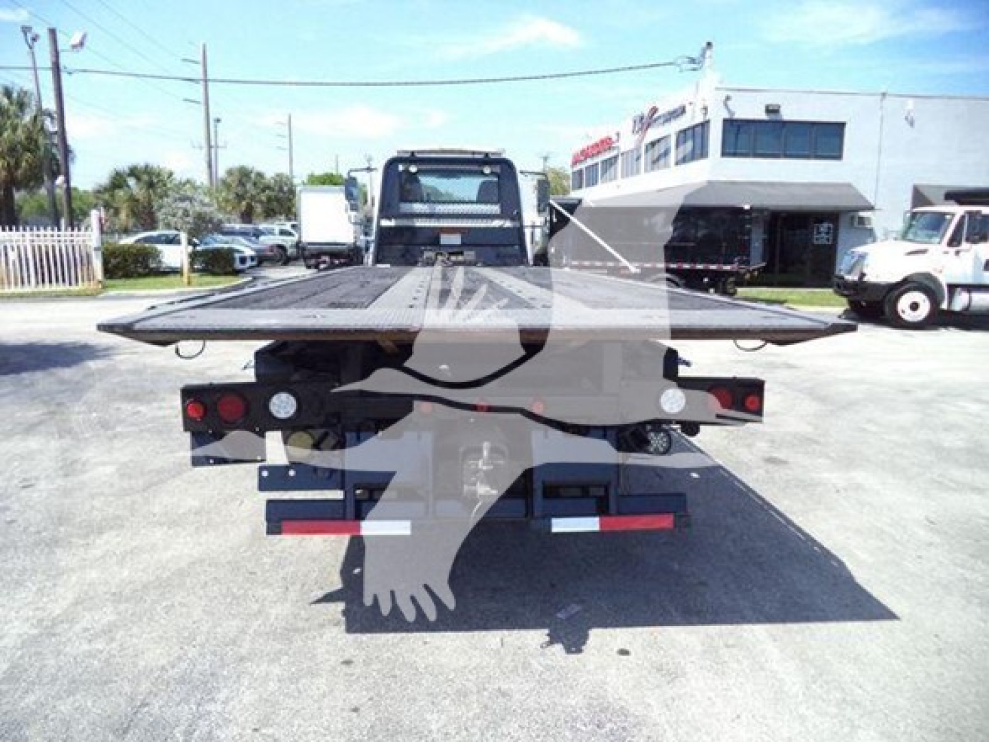 Flatbed tow truck rear view showing bumper lights and license area.