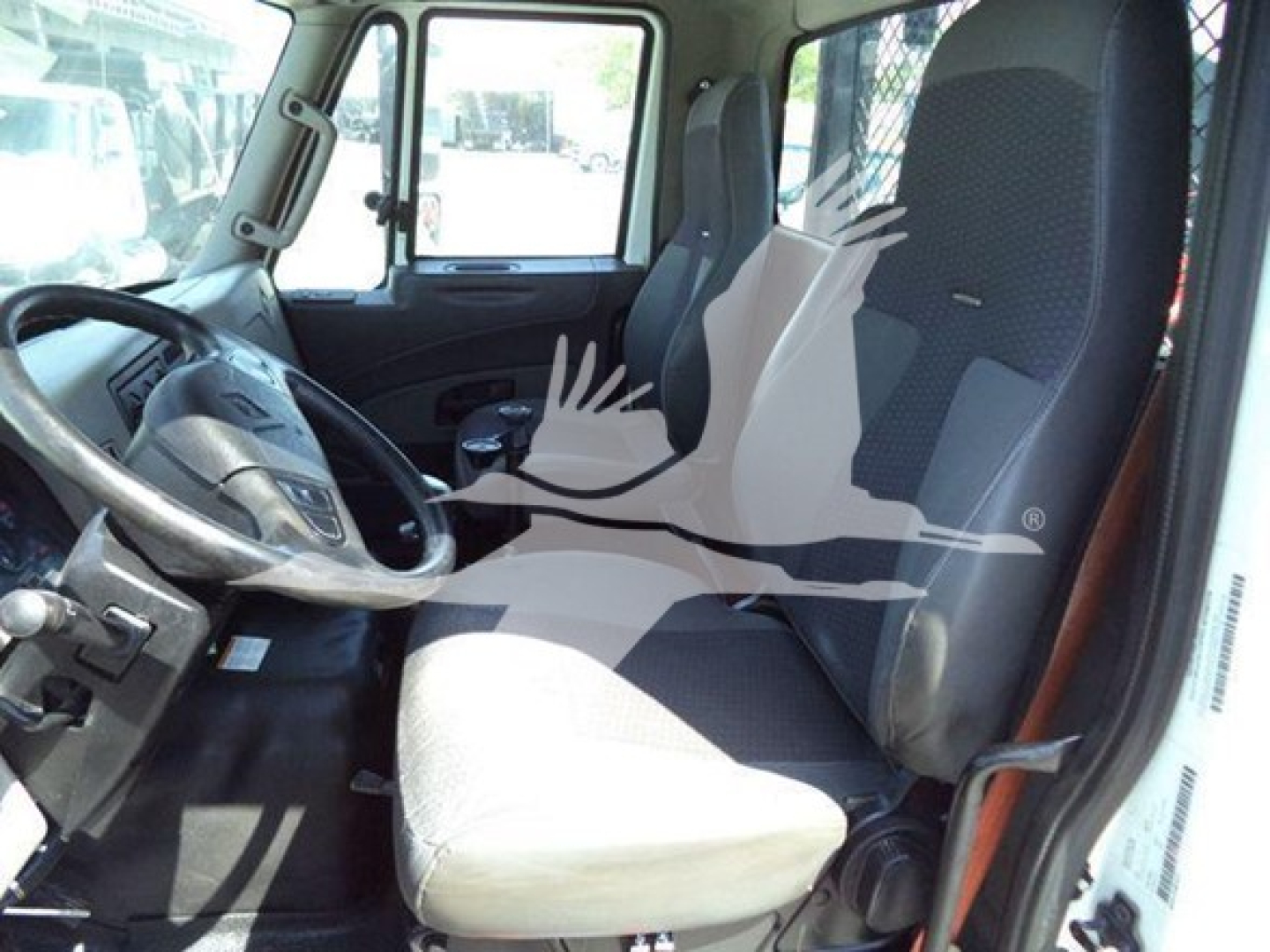 Interior of a 2016 International Workstar 7600 cab showing driver seat and passenger seat with steering wheel and dashboard.