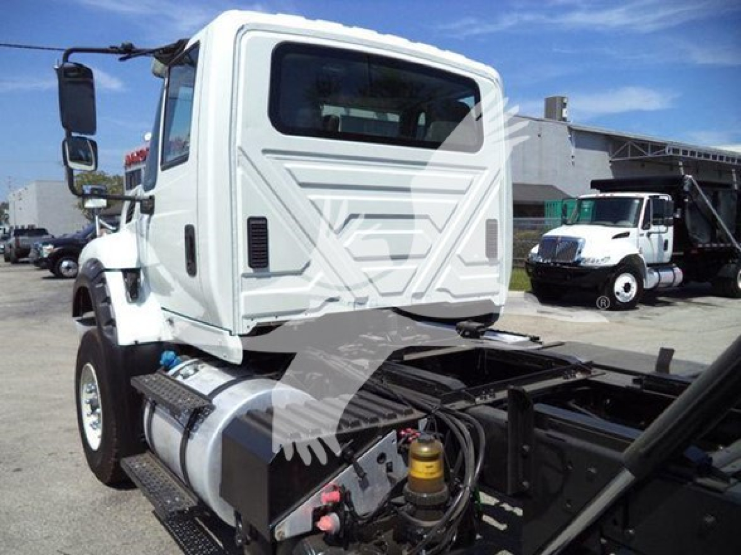 Truck cab of a 2016 International Workstar 7600 with rollback equipment; side fuel tank, hydraulic lines, and rear chassis visible; window text not legible.
