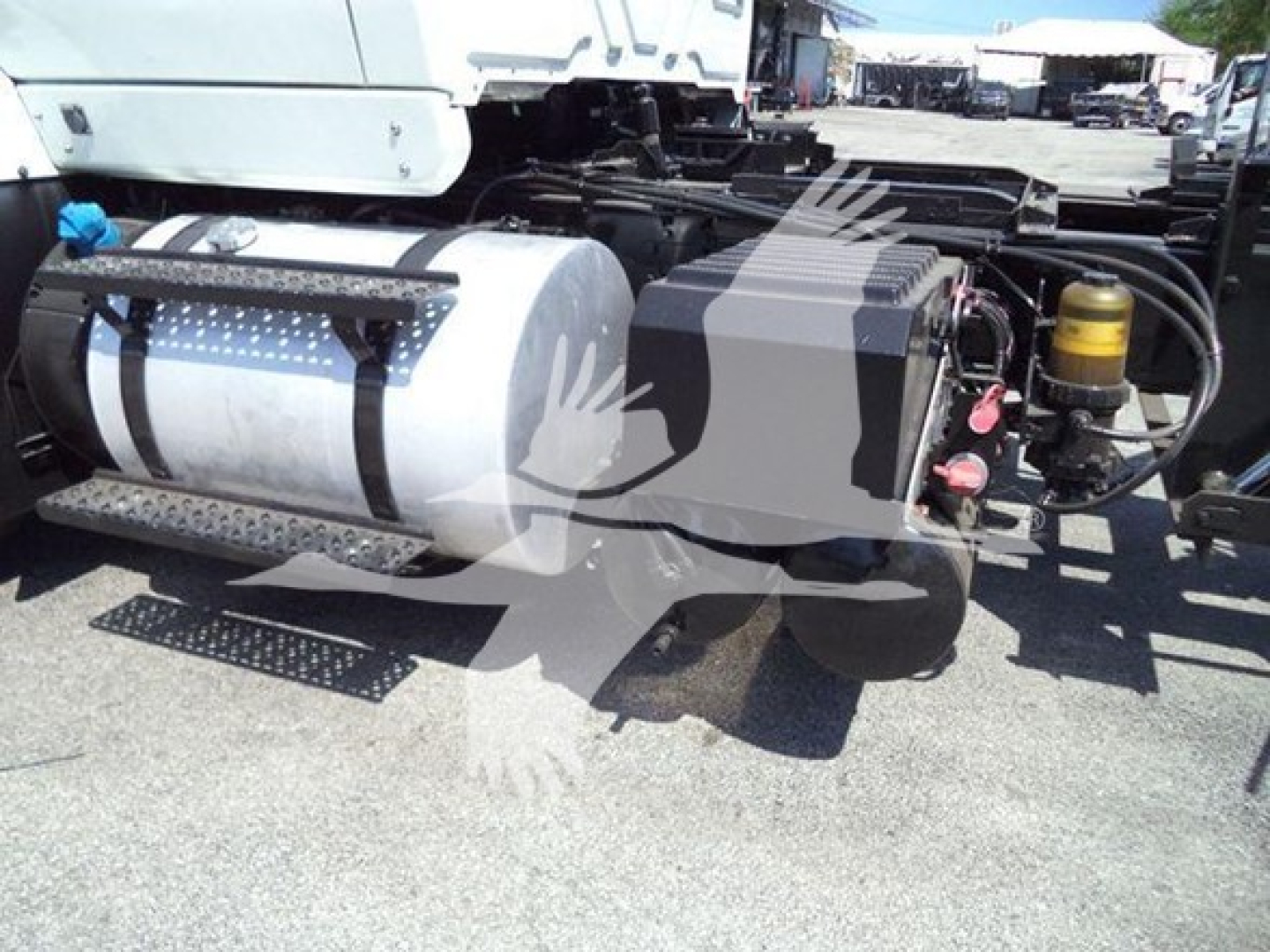 Fuel tank and side components of a 2016 International Workstar 7600 rollback truck chassis showing cylindrical tank and hydraulic reservoir.