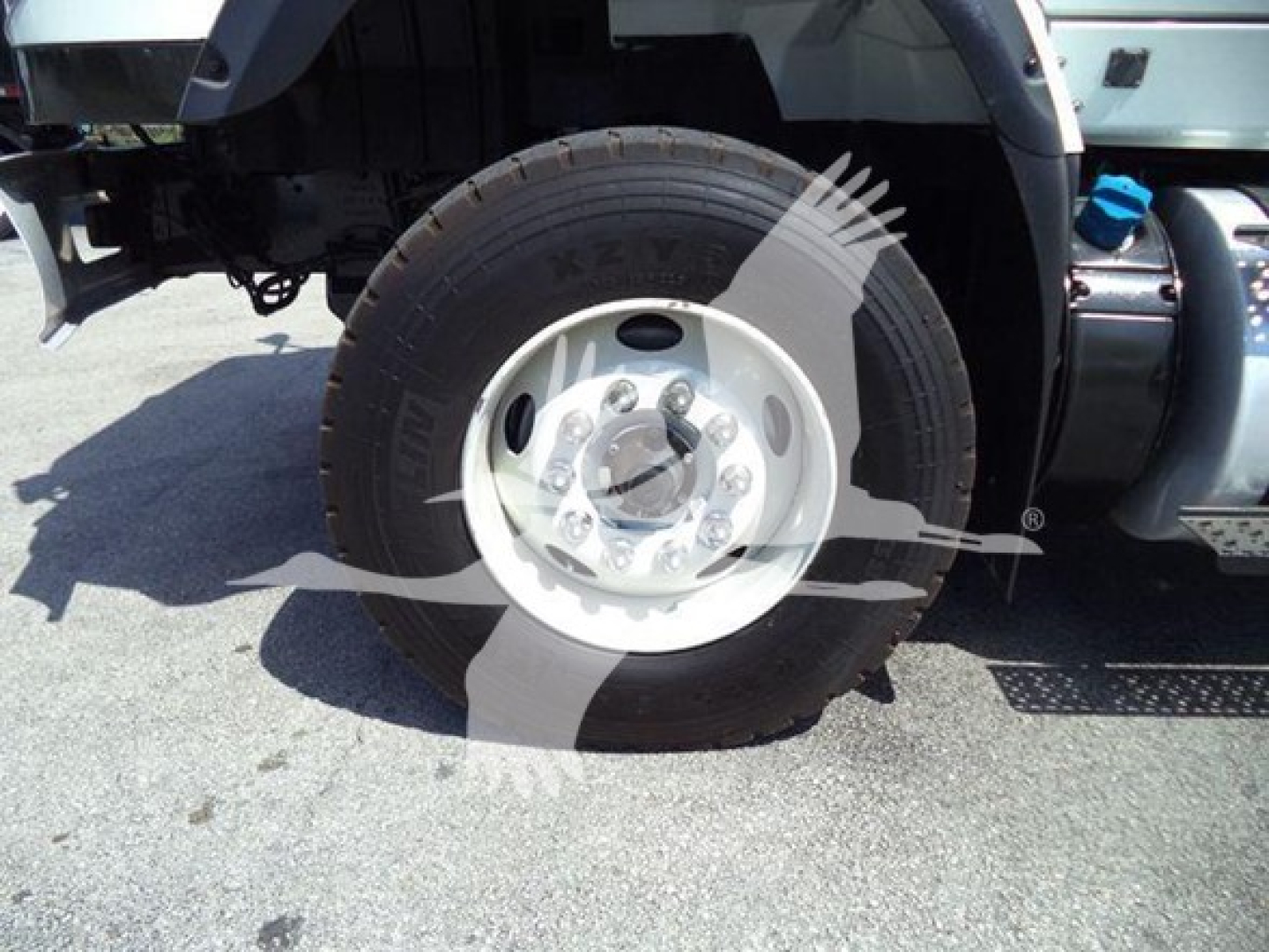 Wheel and tire on front left of a 2016 International Workstar 7600 rollback truck; visible text on tire reads 'KUMHO' and tire size marking; surrounding components include part of fender and step plate.