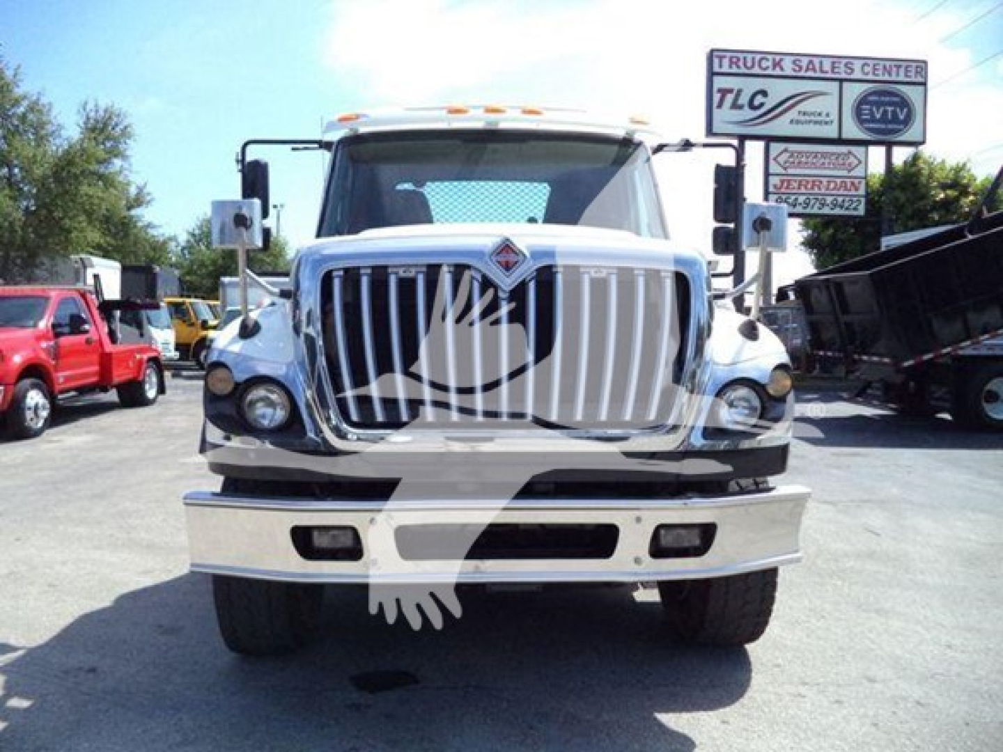 Front view of a white 2016 International Workstar 7600 rollback truck with large grille and bumper, dealership lot in background.