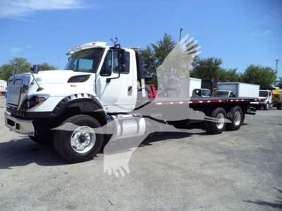 Truck inventory image showing a white 2016 International Workstar 7600 rollback wrecker chassis with extended flatbed and hydraulic winch.
