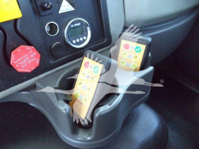 Two-control stalks in vehicle cockpit with safety labels and dashboard gauges visible.