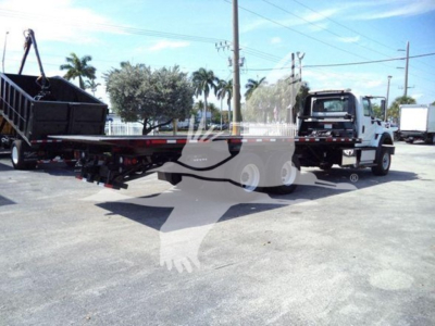 Truck carrier showing a white International Workstar 7600 rollback truck with a flatbed and hydraulic winch, VIN plate not legible, stock number T26270.